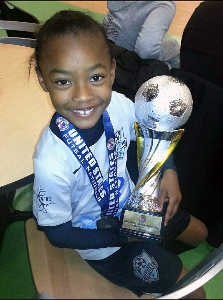 San Diego soccer player Jaedyn Shaw who has been selected for the 2024 Paris Olympics as a kid with a trophy